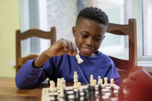 Büyükanne ve torun evde satranç oynuyorlar. 