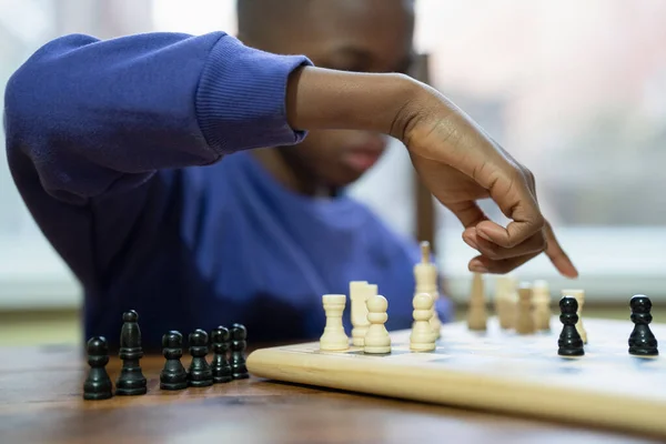 Çocuk evde satranç oynuyor. 