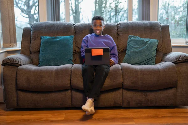 Koltukta oturan dizüstü bilgisayar ile çocuk