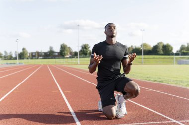 Atlet koşu pistinde koşmaya hazırlanıyor