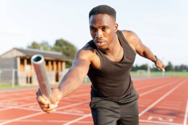 Yarış sırasında elinde bayrak taşıyacak bir atlet.