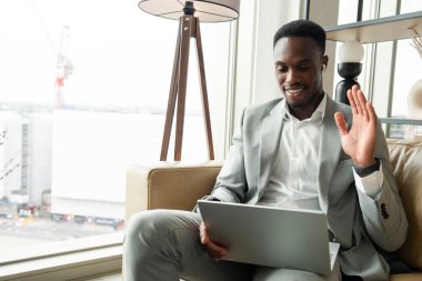 Young businessman sitting on sofa and using laptop