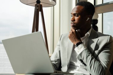 Young businessman sitting on sofa and using laptop