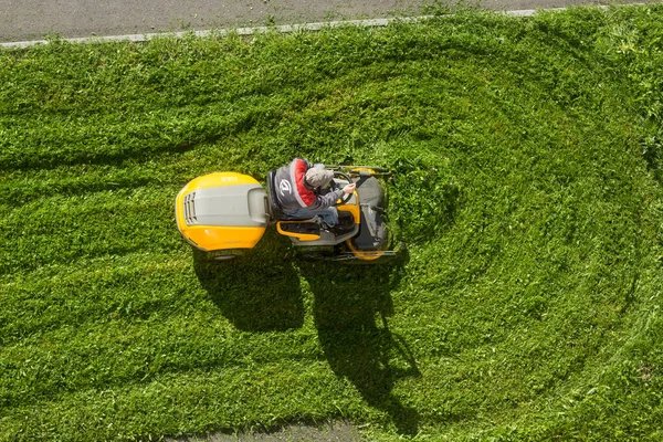 Russie Peterhof 14.09.2020.man dans une tondeuse uniforme de travail pelouse avec un jardinier — Photo