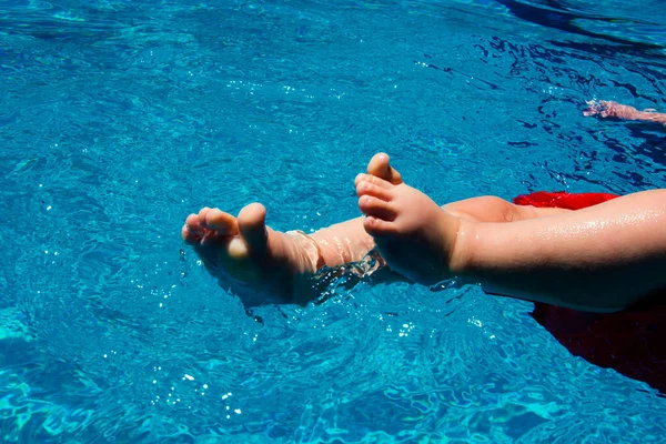 Pies de bebé en la piscina Divertirse Imágenes de stock libres de derechos