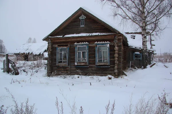 wooden house in winter in the snow