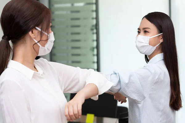 business woman wering mask use elbow hello instead of hand shake.