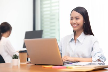 İş kadını Asyalı kadın laptopta çalışırken çok mutlu..