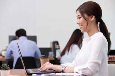 Asyalı iş adamı ve kadın ofiste konuşur ve işi kağıda döker.