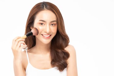 Güzel Asyalı kadın makyaj fırçasıyla makyaj fırçası ve neşe dolu