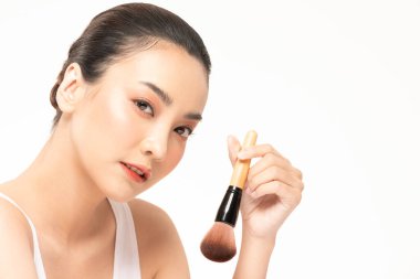 Güzel Asyalı kadın makyaj fırçasıyla makyaj fırçası ve neşe dolu