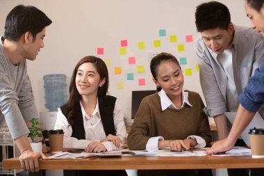 Asyalı iş adamı ve kadınlar ofiste iş konuşuyorlar..