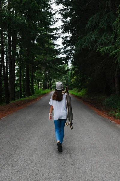 Hedeflerine ulaşmak için omuzlarında tahtayla yürüyen bir kadın.