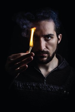 Bir adamın portresi. Adam kibrit yakıyor. Gösterişsiz fotoğrafçılık. Kendine güvenen ve kendini beğenmiş bir görünüm. Motivasyon kavramı
