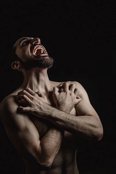 Çığlık at. Çığlık atan bir adamın fotoğrafı. Çıplak gövde. Parmaklar cesedin içine gömülmüş. Yürek acısı ve umutsuzluk hissi. İç işkence