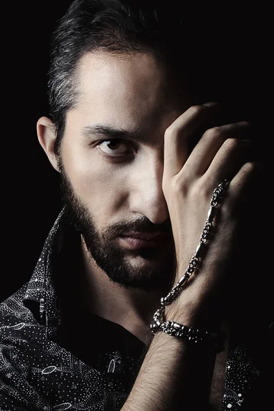 Gösterişsiz bir adamın portresi. Yüzün sadece yarısı yanıyor. El yüzünün yarısını kaplıyor. Elinde gümüş bir zincir var. Erkek portresi