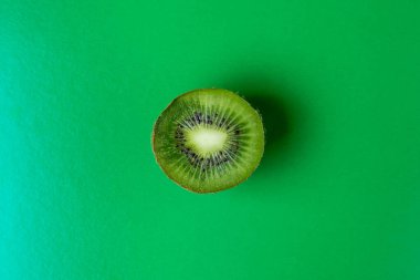 Yeşil arka planda kivi. Kivi kesimi. Yukarıdan bir fotoğraf. Arka plan olarak Kiwi. Egzotik meyve