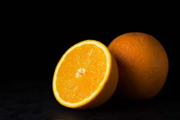 Naranjas Sobre Fondo Negro Una Naranja Corta Por Mitad Otra — Foto de Stock