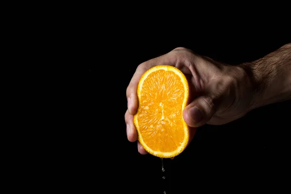 Hand Squeezes Orange Black Background Orange Cut Half — Stock Photo, Image