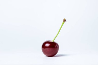 Beyaz arka planda kiraz. Filizli bir kırmızı kiraz