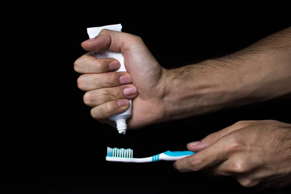 Uma Mão Masculina Espreme Uma Pasta Dentes Uma Escova Dentes — Fotografia de Stock