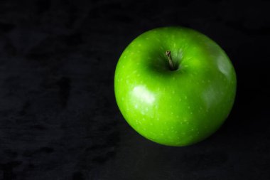 Siyah arka planda yeşil elma. Çerçevede bir yeşil elma
