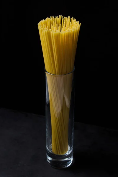 Espaguete Sobre Fundo Preto Esparguete Longo Amarelo Uma Xícara Vidro — Fotografia de Stock