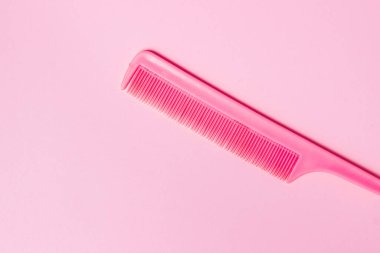 Pembe arka planda pembe tarak. Kuaför konsepti. Güzellik ve Moda