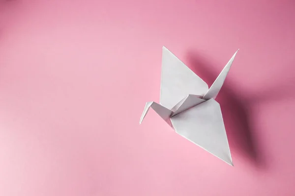 粉色背景的纸鹤 白色纸鹤躺在右边 铭文或标志的位置 Diy Origami — 图库照片
