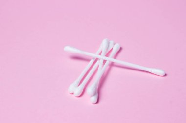 Pembe arka planda pamuk tomurcukları. Bir kaç pamuk tomurcuğu birbirinin üstüne yatar..