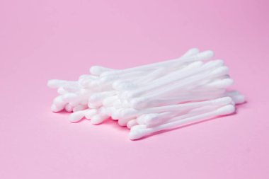 Pembe arka planda pamuk tomurcukları. Bir grup pamuk tomurcuğu birbirinin üstüne yatar.