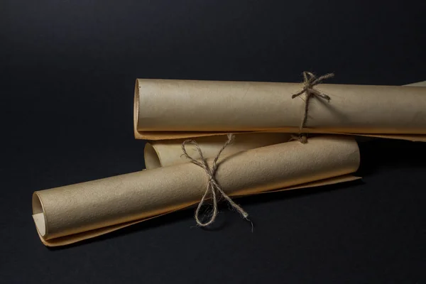 Eski parşömenler siyah arka planda üst üste yatar. Eğitim konsepti. Eski bilgi.