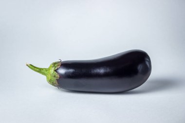 Beyaz arka planda patlıcan. Çerçevenin ortasında taze bir patlıcan var..