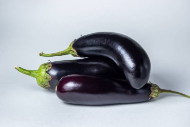 Beyaz arka planda patlıcan. Çerçevenin ortasında birkaç taze patlıcan var..