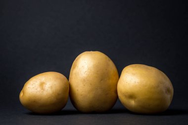 Siyah arka planda patatesler. Yeni patatesler Hasat. Tarım