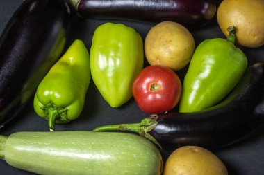 Siyah arka planda sebzeler. Siyah arka planda çeşitli taze sebzeler yatar. Hasat..