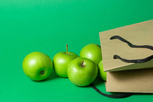 Grüne Äpfel Auf Grünem Hintergrund Äpfel Fielen Aus Papiertüte — Stockfoto