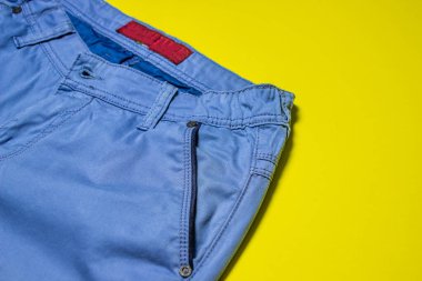 Klasik pantolon işte. Sarı arka planda mavi klasik pantolon. Erkek modası. Modern biçim