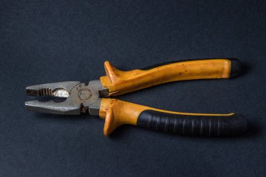 Siyah arka planda kerpeten. Paslı pense. Yapı aracı.