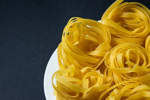 Nesten Van Pasta Een Zwarte Achtergrond Italiaanse Pasta Pasta Nesten — Stockfoto