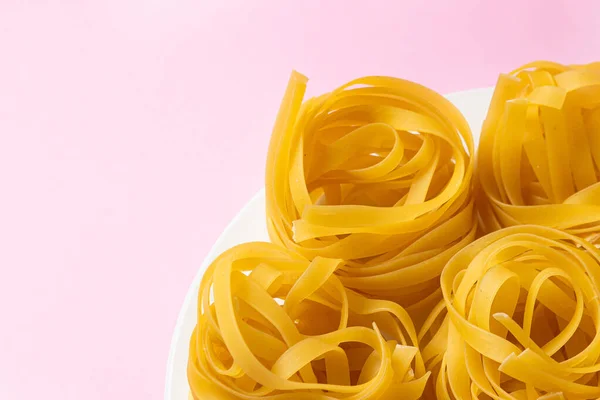 Nest Van Pasta Een Roze Achtergrond Italiaanse Pasta Pasta Nesten — Stockfoto