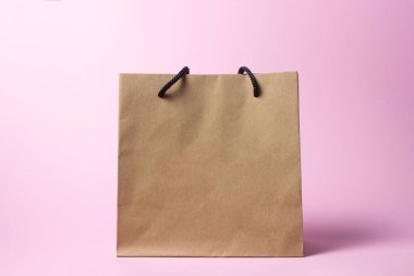 Pembe arka planda bir kese kağıdı. Kese kağıdında harf ya da logo için yer var.
