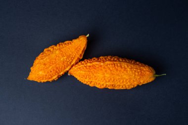 Siyah arka planda Momordica. Egzotik bir sebze. İki anne yan yana yatar.