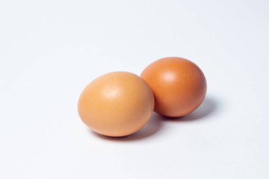 Beyaz arka planda yumurtalar. İki tavuk yumurtası yan yana yatar.