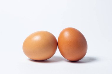 Beyaz arka planda yumurtalar. İki tavuk yumurtası yan yana yatar.