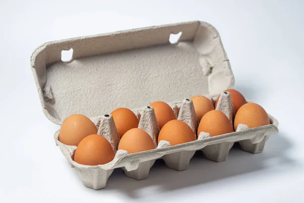 Eggs on a white background. Chicken eggs in a paper box
