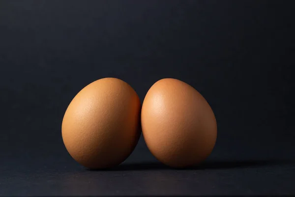 Huevos Sobre Fondo Negro Dos Huevos Pollo Uno Lado Del — Foto de Stock