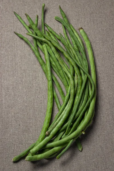 green beans. Green string beans lie on a jute fabric. Harvesting