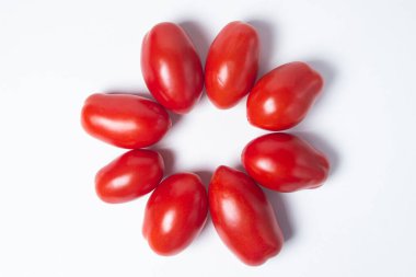 Beyaz arka planda domatesler. Kırmızı domatesler daire şeklinde uzanır.