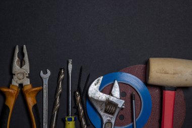 Siyah arka planda çalışan araçlar. Ev geliştirme ya da onarım projeleri için kullanılmış ve kirli iş araçları. El emeği konsepti. Yazıt ya da logo için bir yer var.